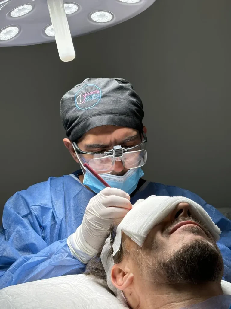 Médico especializado realizando un injerto capilar en paciente, aplicando técnica avanzada para restaurar el cabello.